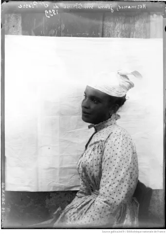 Photographie en noir et blanc d'une femme portant une coiffe à un bout